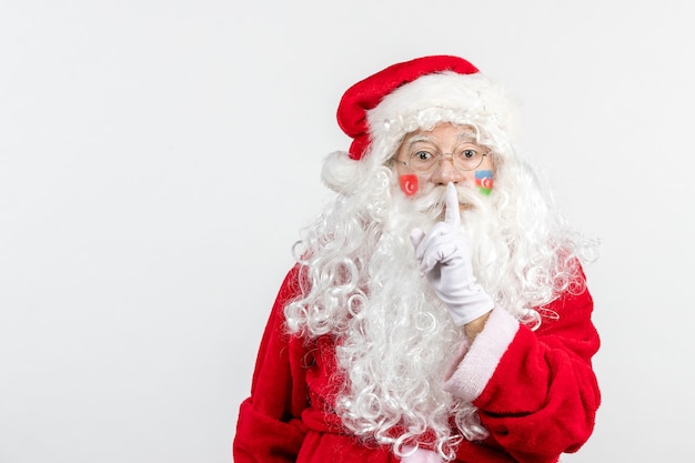 Front view of santa claus with azerbaijani and turkish flag paints on his face on white wall