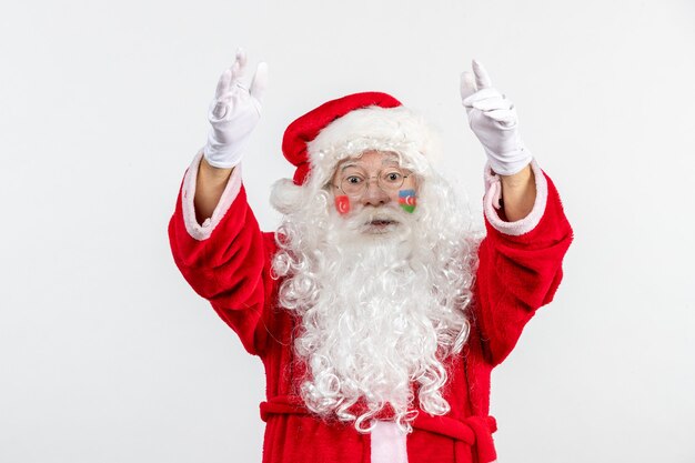 Front view of santa claus with azerbaijani and turkish flag paints on his face on white wall