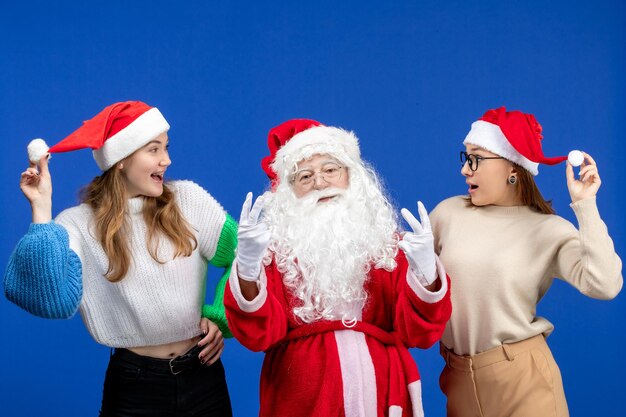 Front view santa claus with females on a blue holiday cold christmas new year snow