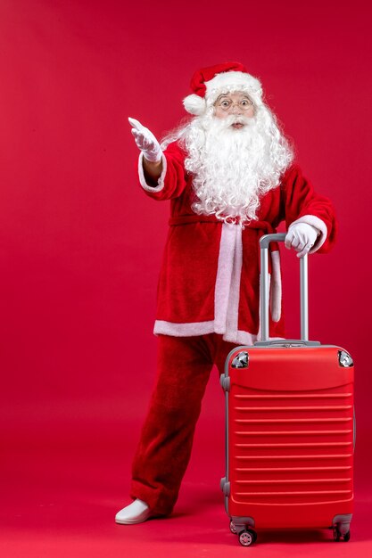 Front view of santa claus with his red bag on a red wall