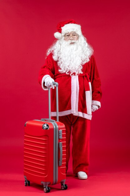 Front view of santa claus with his red bag on red wall