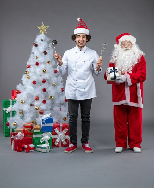 크리스마스 주위 남성 요리사와 산타 클로스의 전면보기 회색 벽에 흥분 선물