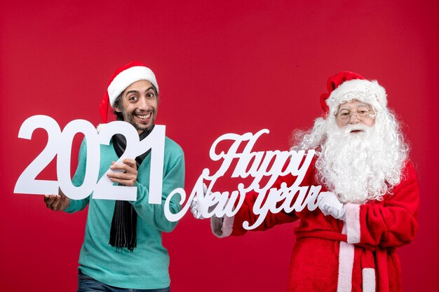 Front view santa claus with male holding and happy new year writing on red emotion new year