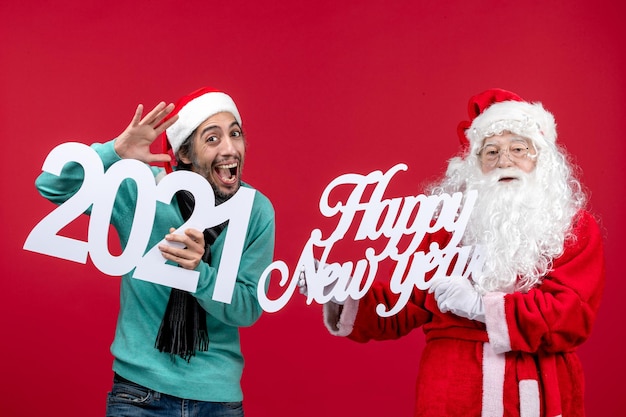 Front view santa claus with male holding and happy new year writing on red new year christmas holiday present emotion