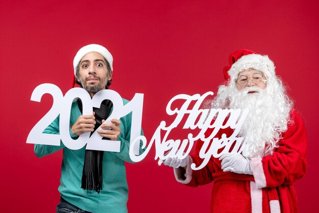 Front view santa claus with male holding and happy new year writing on red new year christmas