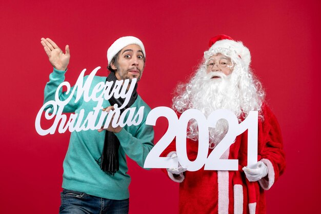 front view santa claus with male holding and merry christmas writings on red christmas emotion