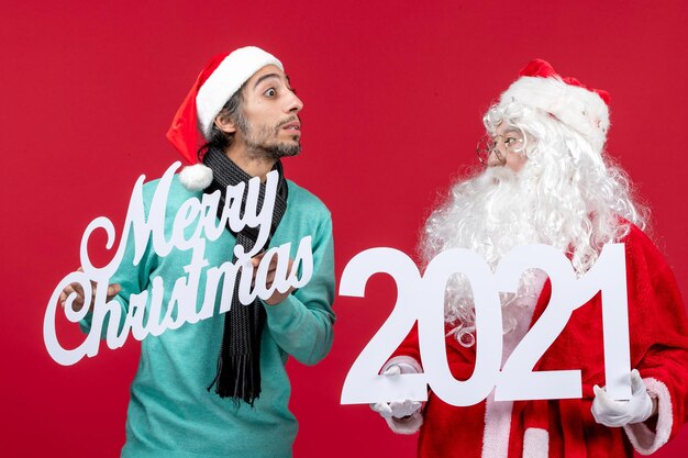 front view santa claus with male holding and merry christmas writings on red christmas present