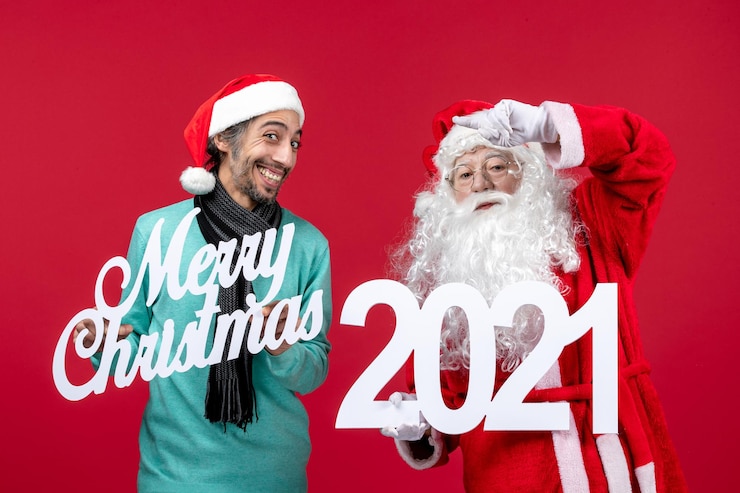 無料Photo 男性の保持と赤い新年の感情のメリークリスマスの書き込みと正面のサンタクロース
