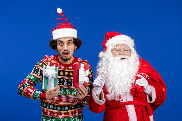 Front view santa claus with young male holding presents