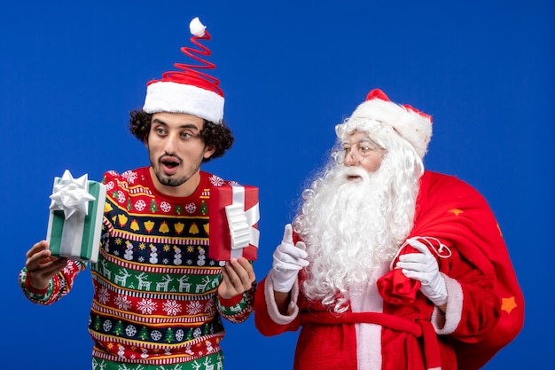 Front view santa claus with young male holding presents