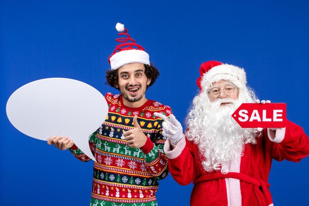 Front view santa claus with young male holding white sign and sale writing