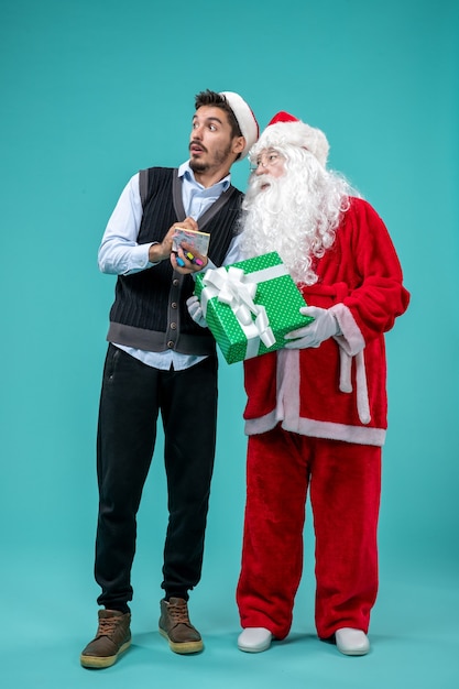 Front view santa claus with young male who's taking notes on blue background