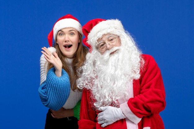 파란 벽에 젊은 예쁜 여자와 산타 클로스의 전면 보기