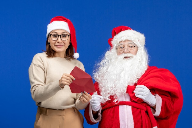 Санта-клаус и молодая женщина, открывающее письмо на синем празднике, рождество, новый год, вид спереди