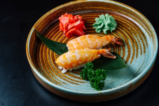 Вид спереди суши сашими с креветками с васаби и имбирем на тарелке
