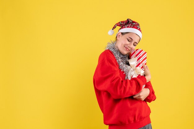 빨간 스웨터와 그녀의 선물을 들고 산타 모자와 전면보기 만족 된 소녀
