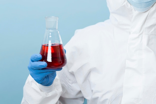 Free photo front view scientist holding a red chemical