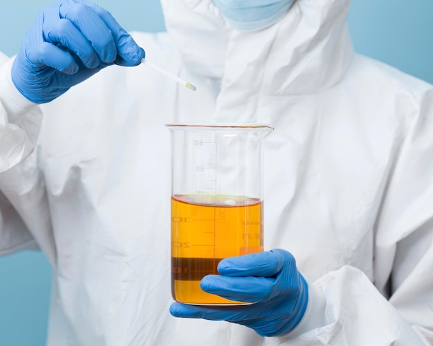 Front view scientist holding a yellow chemical