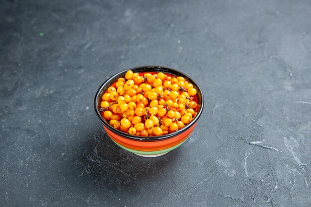 Front view sea buckthorn in bowl on dark red surface free place