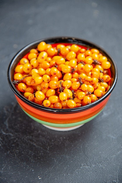 Front view sea buckthorn in bowl on dark red surface