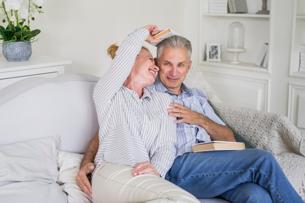 Free photo front view senior couple playing with books