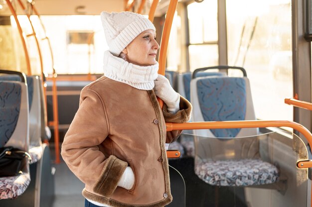 Вид спереди старший женский езда на автобусе