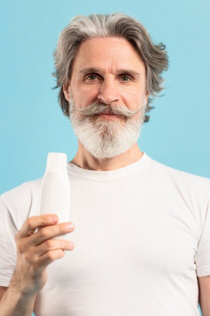 Front view of senior holding moisturizer