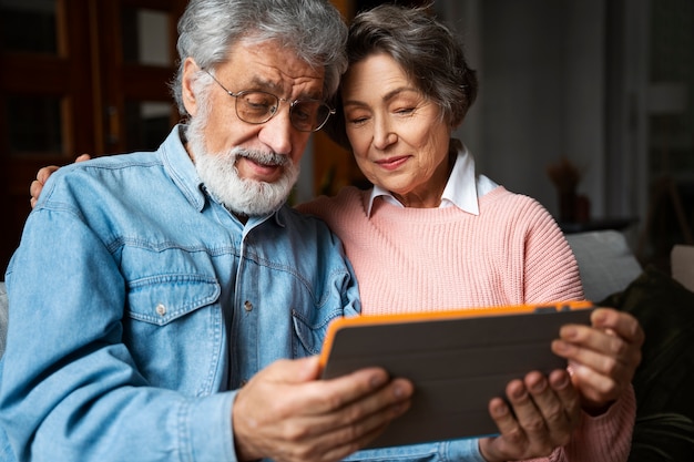 Foto gratuita persone anziane di vista frontale con tablet