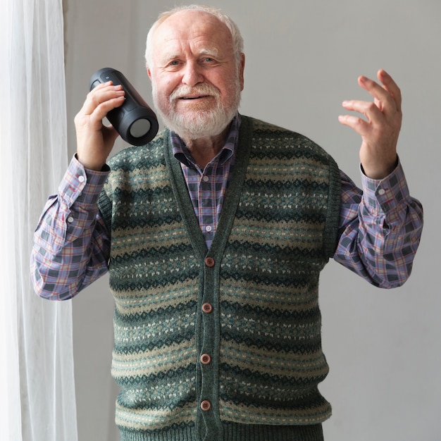 Free photo front view senior playing songs on speaker