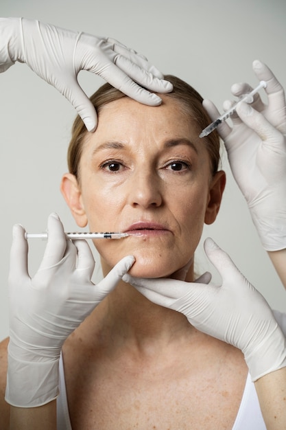 Front view senior woman getting facial injections