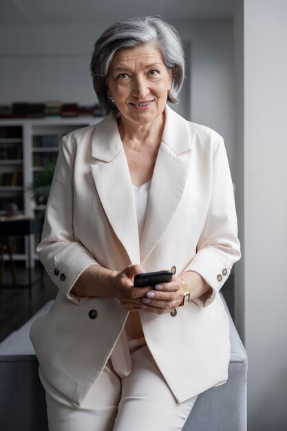 Front view senior woman holding smartphone