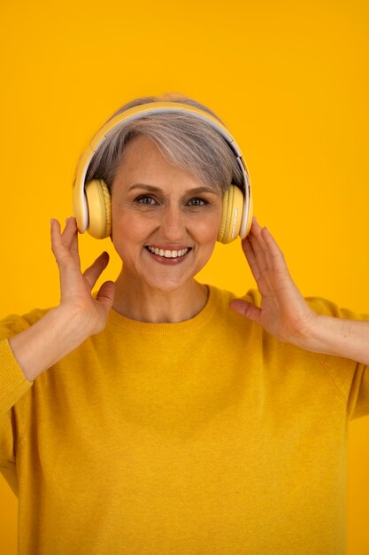 Front view senior woman posing with headphones