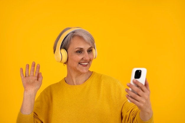 Front view senior woman posing with headphones