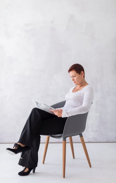 Front view senior woman reading a magazine