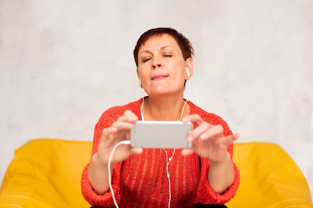 Foto gratuita donna senior di vista frontale che prende i selfie