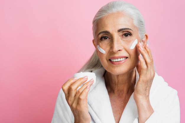 Front view senior woman testing moisturizer