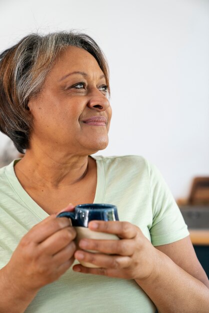 Donna senior di vista frontale con la tazza di caffè