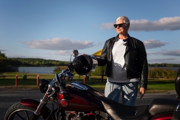 Free photo front view senior woman with motorcycle