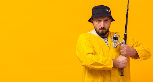 Free photo front view of serious fisherman holding fishing rod