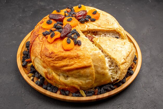 Front view shakh plov delicious rice meal cooked inside round dough with raisins on grey space