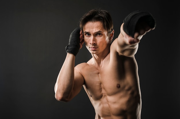 Front view of shirtless athlete with boxing gloves