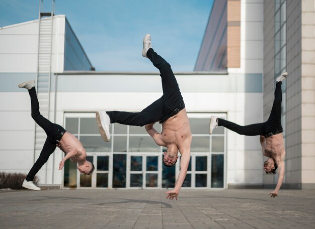 Front view of shirtless hip hop artists practicing outside