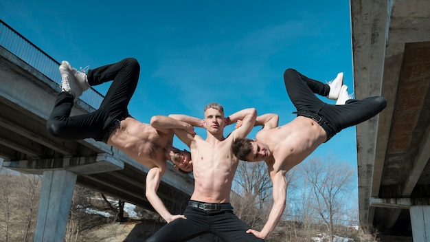 Free photo front view of shirtless hip hop performers posing outside