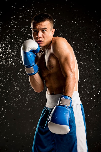 Вид спереди боксера без рубашки с защитными перчатками