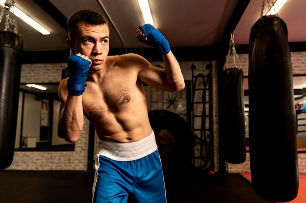 Front view of shirtless male boxer working out