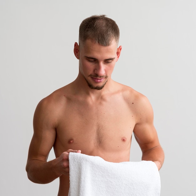 タオルを持っている上半身裸の男の正面図