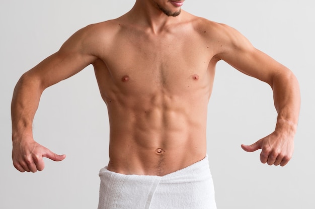 Front view of shirtless man showing off his abs