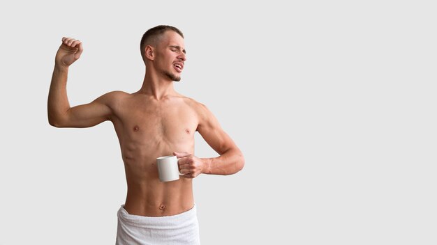 Front view of shirtless man stretching in the morning