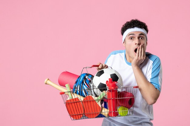 Front view shocked young male in sport clothes with basket full of sport things