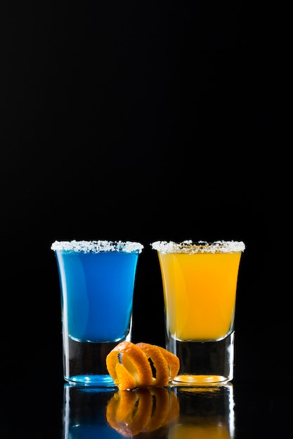 Front view of shot glassed with colored cocktails